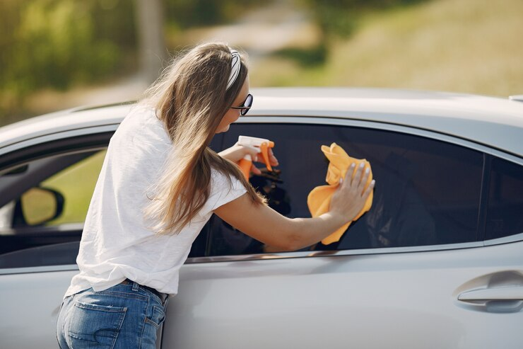 Woman Wipes the Car with a Rag