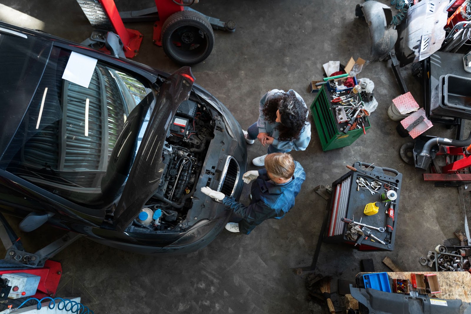Top view of man speaking with customer and repair a car