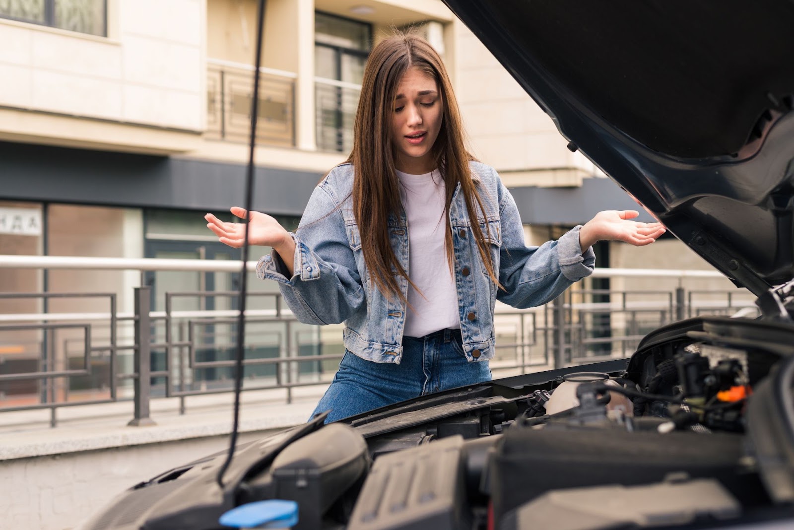 Worried girl near her broken car