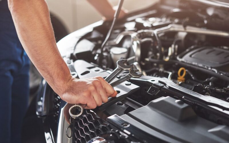 Car service worker repairing vehicle