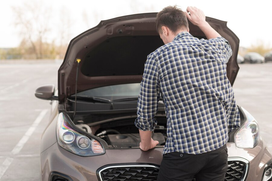 A man looking under the hood of a car