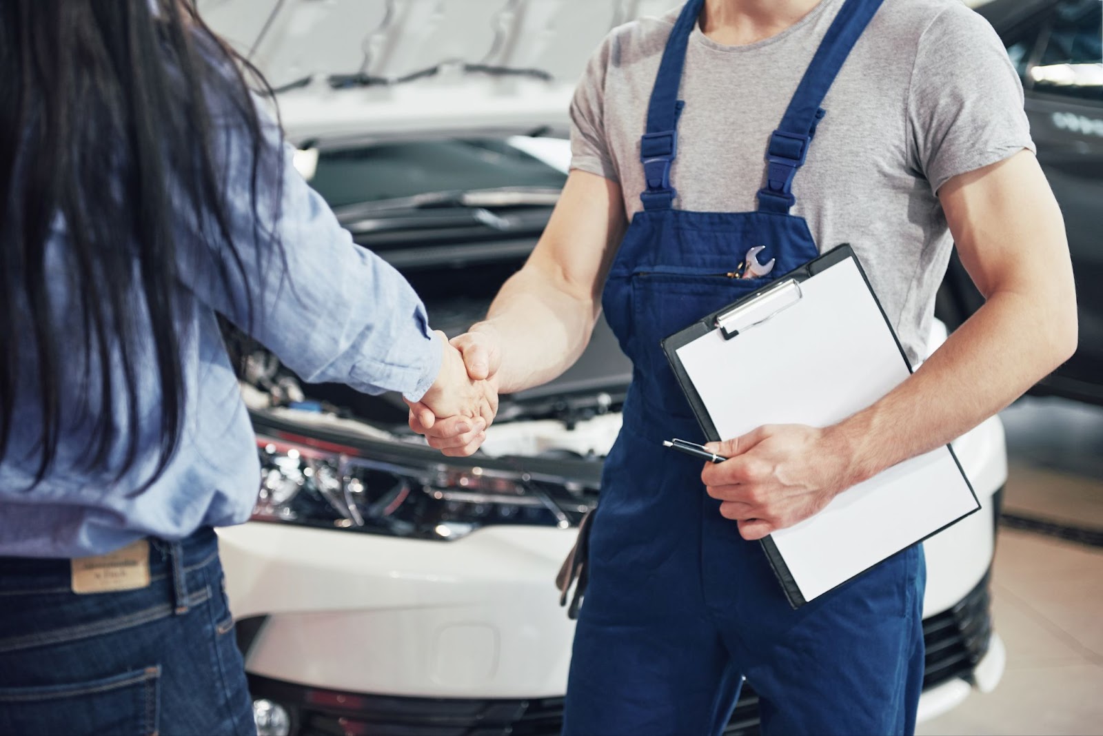 Mechanic and woman customer make an agreement on the repair of the car