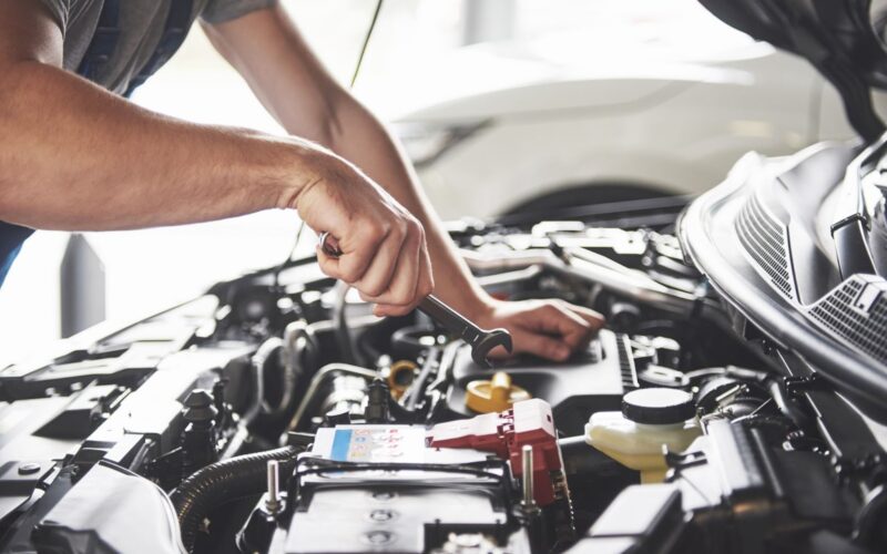 Car service worker repairing vehicle