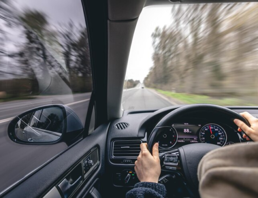 Woman Drivers Hands on a Car Steering Wheel